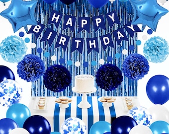 May include: A festive birthday party scene with blue and white decorations. Includes balloons, star-shaped foil balloons, paper pom-poms, a banner that reads "Happy Birthday", and a cake on a white stand. The table is covered with a blue and white striped tablecloth.