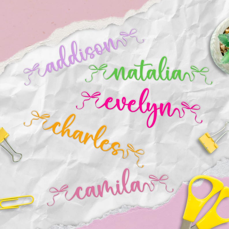 K&ouml;nnte beinhalten: F&uuml;nf Namen in Schreibschrift, jeweils mit einer Schleife, in verschiedenen Farben: Lila, Gr&uuml;n, Pink, Orange und Hellrosa. Die Namen sind "Addison", "Natalia", "Evelyn", "Charles" und "Camila". Der Hintergrund ist wei&szlig; und strukturiert.