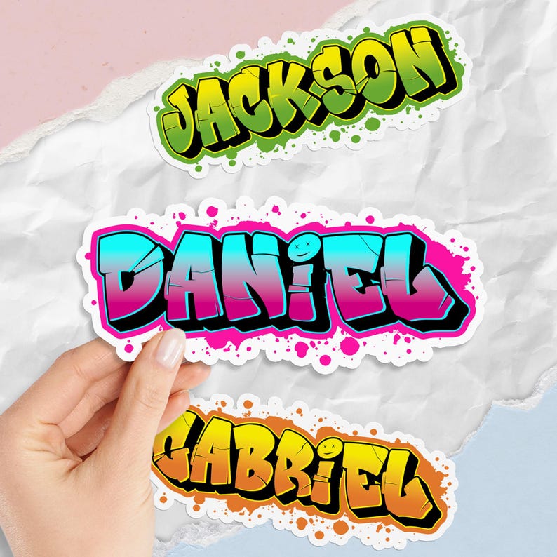 May include: Three colorful graffiti-style name stickers: "Jackson" in green and yellow, "Daniel" in blue and pink, and "Gabriel" in orange and yellow. Each sticker has a black outline and a splatter effect.