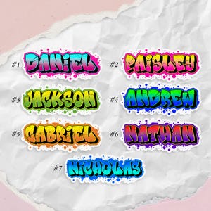 May include: A collection of seven name stickers in a graffiti style. Each sticker features a different name: Daniel, Paisley, Jackson, Andrew, Gabriel, Nathan, and Nicholas. The names are in bold, colorful lettering with a black outline.