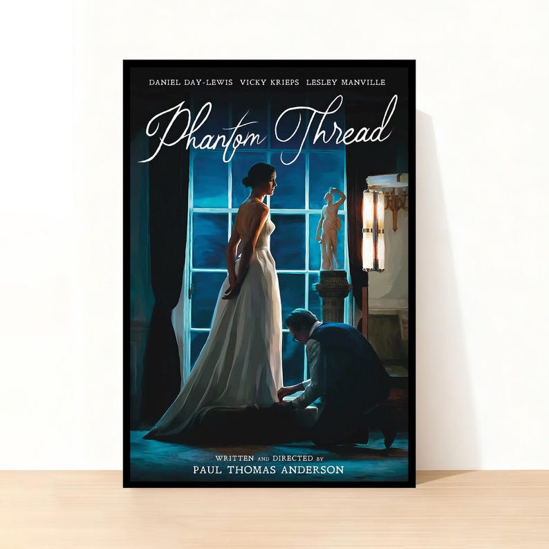May include: A framed poster for the film "Phantom Thread", starring Daniel Day-Lewis, Vicky Krieps, and Lesley Manville. The poster depicts a woman in a white dress near a window, with a man kneeling. The title is in a flowing script.