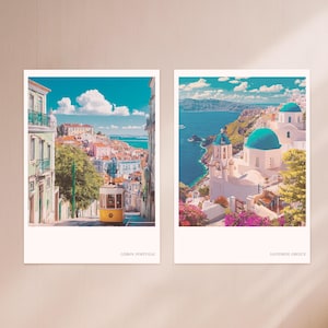 Puede incluir: Dos impresiones artísticas de viaje enmarcadas. Una presenta un tranvía amarillo en una calle de Lisboa, Portugal, con el texto "LISBON, PORTUGAL". La otra muestra edificios blancos con cúpulas azules en Santorini, Grecia, con el texto "SANTORINI GREECE".