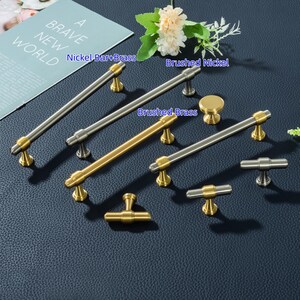 K&ouml;nnte beinhalten: Eine wei&szlig;e Keramik-Tasse mit schwarzem Henkel und dem handgeschriebenen Text "But First, Coffee". Die Tasse steht auf einer wei&szlig;en Oberfl&auml;che. F&uuml;r Hei&szlig;getr&auml;nke geeignet.