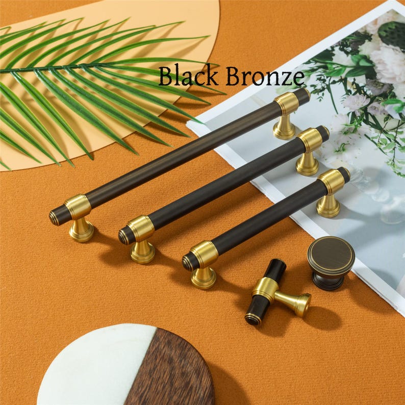 Pode incluir: Conjunto de ferragens para arm&aacute;rios em bronze preto. O conjunto inclui v&aacute;rios tamanhos de puxadores de barra, um bot&atilde;o e um puxador em T. As ferragens t&ecirc;m um acabamento preto com detalhes dourados. O texto "Black Bronze" &eacute; vis&iacute;vel.
