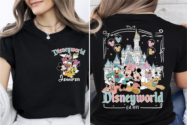Op de afbeelding: Zwart T-shirt met een Disneyworld-ontwerp. De voorkant toont Disney-personages en de naam "Jennifer". De achterkant toont het Disney-kasteel, meer personages en de tekst "Disneyworld Est. 1971".
