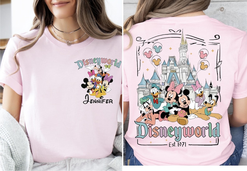 Op de afbeelding: Lichtroze T-shirt met een Disney World-ontwerp. De voorkant toont Disney-personages en de naam "Jennifer". De achterkant toont het Disney World-kasteel en meer personages, met "Disneyworld Est. 1971".