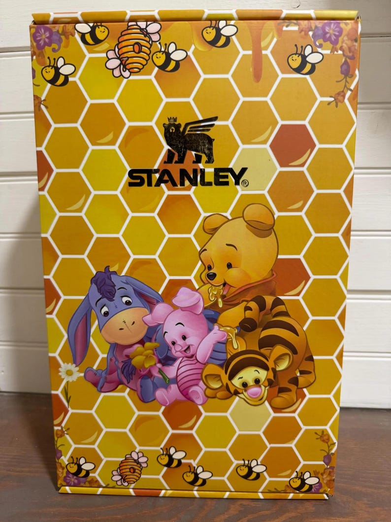 May include: A yellow box with a honeycomb pattern and illustrations of Winnie the Pooh characters. The box features the Stanley logo and images of bees, honey, and flowers. Characters include Winnie the Pooh, Piglet, Eeyore, and Tigger.