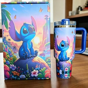 May include: A rectangular cardboard box and a matching stainless steel tumbler with a handle, both featuring a vibrant illustration of the blue character Stitch sitting on a rock amidst a tropical landscape with flowers, butterflies, and a sunset.