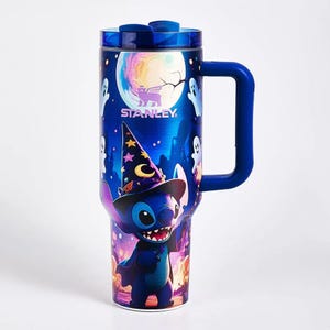May include: A blue Stanley tumbler featuring a graphic of Stitch wearing a wizard hat, surrounded by ghosts and a full moon. The cup has a sturdy side handle and a translucent blue lid with a sliding closure, showcasing a vibrant Halloween theme.
