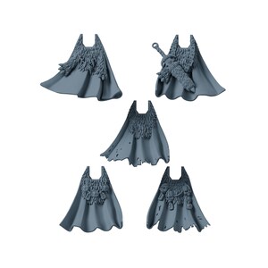 Op de afbeelding: Een set van vijf grijze miniatuurcapes voor spelfiguren. Elke cape heeft unieke details, waaronder vachttexturen, een zwaard op de rug, schedelornamenten en gerafelde randen. Deze plastic onderdelen zijn ontworpen voor tafelmodel miniaturen.