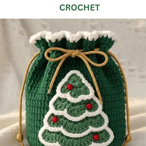 Puede incluir: Mini bolso de ganchillo verde con un diseño de árbol de Navidad blanco y rojo. El bolso tiene un cierre de cordón con cordón dorado y un ribete blanco. El texto "MINI BAG CHRISTMAS CROCHET" está en la parte superior.