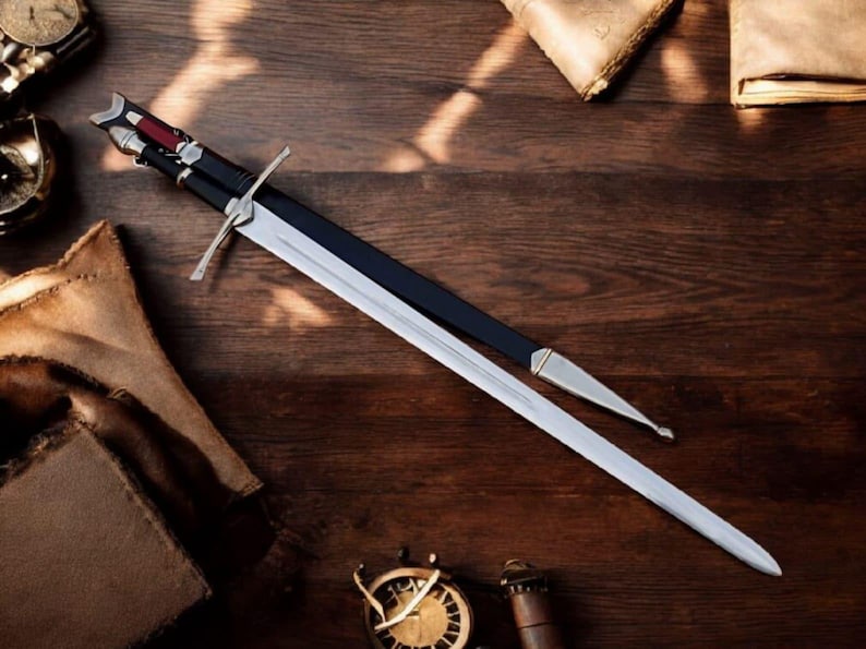 May include: A long, silver sword with a black handle and a silver crossguard, resting on a wooden surface. The sword is partially sheathed in a black scabbard with silver accents. Other items, including a compass and aged paper, are also on the wooden surface.