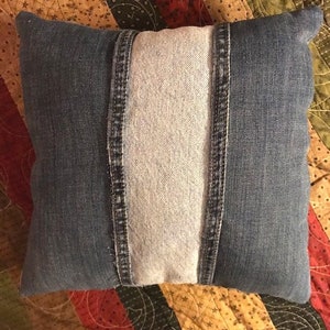 Pu&ograve; includere: Un cuscino in denim blu con un pannello centrale in denim bianco. Il cuscino &egrave; realizzato in denim riciclato e presenta un design unico a patchwork.