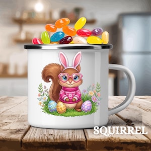 May include: White enamel mug with a cartoon squirrel wearing bunny ears and glasses, holding Easter eggs. The mug is filled with colorful jelly beans, and the word "SQUIRREL" is printed on the bottom.