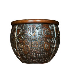 May include: A dark brown, rounded ceramic planter featuring embossed bamboo stalks and numerous variations of the Chinese character 'Fu' in different calligraphic styles, set against a textured, deep-toned background with a smooth, thick rim.