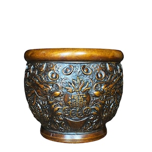 Könnte beinhalten: Eine braune, aufwendig geschnitzte Holzschale mit breitem Rand. Die Schale weist detaillierte Reliefs von Drachen und anderen traditionellen asiatischen Motiven auf. Die Außenseite hat eine dunkelbraune Oberfläche, vor weißem Hintergrund.