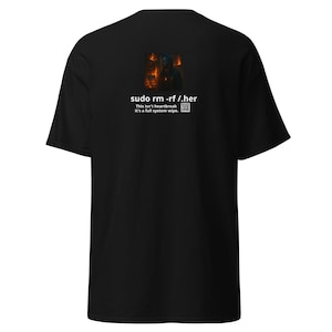 May include: Black t-shirt with a graphic on the back showing a person in front of flames and the text "sudo rm -rf /.her". The text below reads "This isn't heartbreak, it's a full system wipe."
