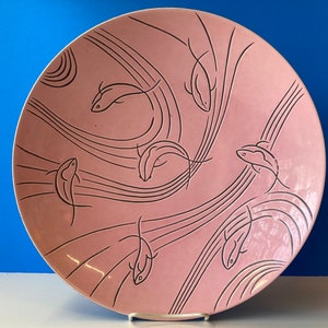 May include: A large pink ceramic serving platter with a black and white design of stylized fish swimming in a stream of wavy lines.