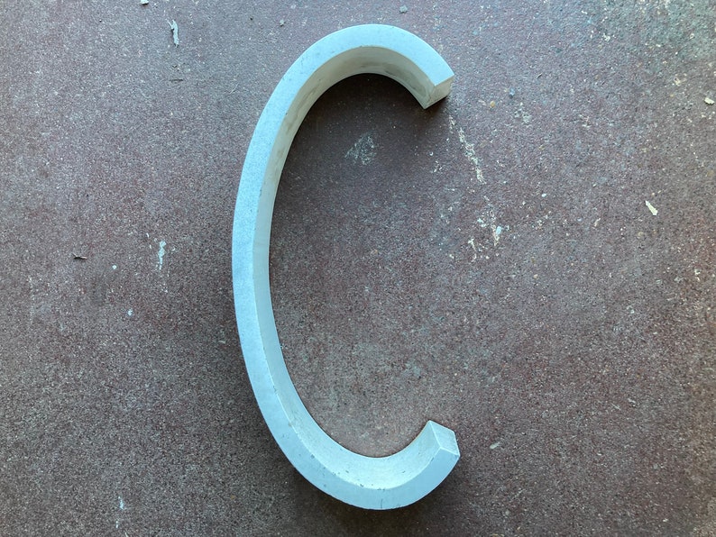 May include: A white, curved, ceramic piece shaped like the letter C.