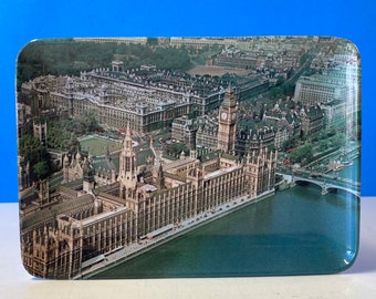 May include: An aerial view of the Houses of Parliament in London, England. The iconic clock tower, Big Ben, is visible in the centre of the image. The River Thames flows in the foreground.