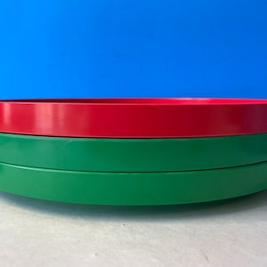 以下が含まれることがあります： 積み重ねることができる3つの丸いトレイ。 上のトレイは赤、真ん中のトレイは緑、下のトレイは緑です。