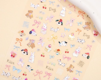 May include: Clear sticker sheet with various watercolor illustrations of teddy bears, bunnies, dogs, bows, and cherries. The words "love", "Dog", and "Rabbit" are written on the sheet. The stickers are in pastel colors.