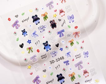 May include: Clear sheet of nail art stickers with various designs. Includes cartoon bears, bows, stars, hearts, flowers, and the text "Sleep!" and "HO HO". The sticker sheet has the text "3D-1048".