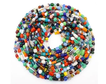 May include: A colorful strand of beads in various shapes and sizes, including round, oval, and cylindrical. The beads are a mix of colors, including red, green, blue, yellow, and white. The beads are strung together to form a circular shape.