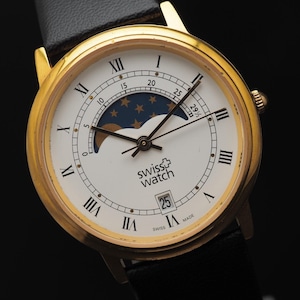 Peut inclure: Une tasse en céramique blanche avec une anse noire et l'inscription "But First, Coffee" en gras noir. La tasse contient un liquide foncé, probablement du café, et repose sur une surface claire.