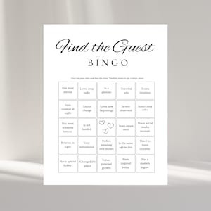 Könnte beinhalten: Ein weißes Papier mit dem Text "Find the Guest BINGO" in eleganter Schrift. Die Bingo-Karte zeigt ein Raster von Feldern mit Aufforderungen wie "Hat im Ausland gelebt" und "Genießt Veränderungen". Drei Herzsymbole sind sichtbar. Ein lustiges Spiel für Partys.