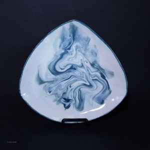 K&ouml;nnte beinhalten: Eine dreieckige Keramik-Servierplatte mit wei&szlig;er Glasur und einem blauen und gr&uuml;nen Marmormuster.