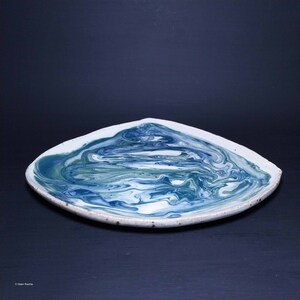 K&ouml;nnte beinhalten: Ein quadratischer Keramikteller mit wei&szlig;em Hintergrund und einem blauen und gr&uuml;nen Marmormuster.
