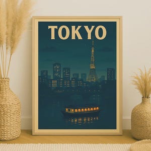 May include: A framed print featuring a nighttime view of Tokyo. The image shows the Tokyo Tower illuminated, a boat with lit windows, and the city skyline under a dark blue sky. The word "TOKYO" is printed in large, beige letters.