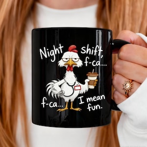 Può includere: Tazza in ceramica nera con un disegno di pollo dei cartoni animati. Il pollo indossa uno stetoscopio e tiene in mano una tazza di caffè. Il testo sulla tazza recita "Night shift, f-ca... f-ca... I mean fun."