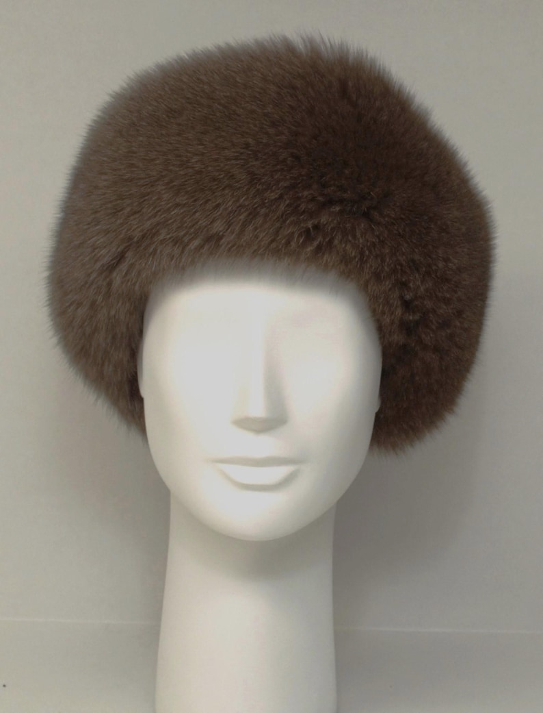 May include: A brown fur hat with a wide brim. The hat is made of soft, fluffy fur and has a simple, classic design.