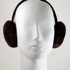 May include: Brown faux fur earmuffs with a black headband. The earmuffs are worn on a white mannequin head.