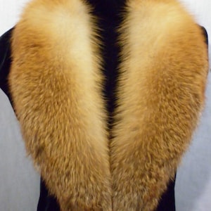 May include: A large, fluffy fox fur collar in a rich orange color. The collar is made of real fur and has a soft, luxurious feel.
