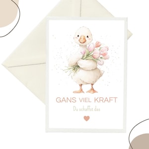 Könnte beinhalten: Eine weiße Grußkarte mit einer Aquarellillustration eines flauschigen weißen Gänsekükens, das einen Strauß rosa Tulpen hält. Der Text GANS VIEL KRAFT Du schaffst das ist in Hellbraun unter dem Vogel gedruckt, ergänzt durch ein kleines rosa Herz.