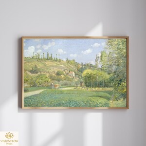 May include: A framed landscape painting with a pastoral scene. The artwork depicts a green field, a winding path, and a distant hillside under a blue sky with clouds. The painting is in a wooden frame.