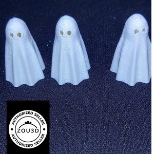 May include: Three small, white ghost figurines with yellow eye cutouts. The ghosts have a simple, draped design. The image includes a black background and a logo that says "ZOU3D Authorized Seller."