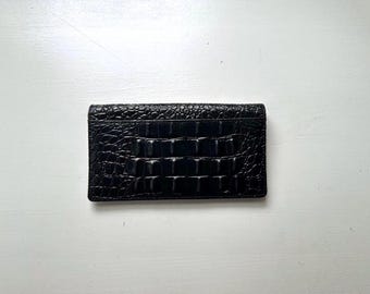 Cartera y portachequera vintage de los años 90 de piel negra con relieve de cocodrilo.