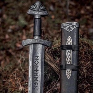 May include: A detailed image of a Viking sword with a dark wooden handle and a silver blade. The blade has the word "NORTHMEN" etched into it. The sword is next to its sheath, which is also dark wood with silver accents.