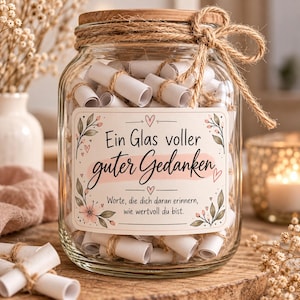 Könnte beinhalten: Ein klares Glasgefäß gefüllt mit kleinen, mit Bindfaden umwickelten weißen Papierrollen. Das Glas hat einen Holzdeckel und ein Etikett mit Blumenillustrationen und dem Text: Ein Glas voller guter Gedanken, Worte, die dich daran erinnern, wie wertvoll du bist.