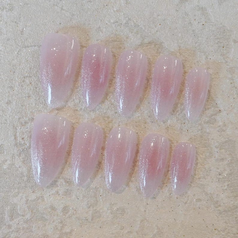 May include: A white ceramic mug with a black handle and the text "But first, coffee" in a black, handwritten-style font. The mug is on a white surface.