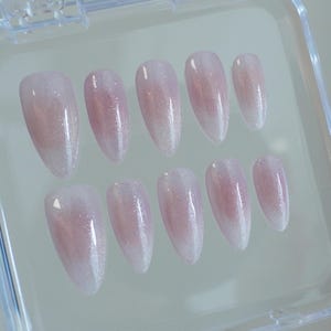 May include: A white ceramic mug with a black handle and the text "But First, Coffee" in a black, handwritten-style font. The mug is on a white surface.