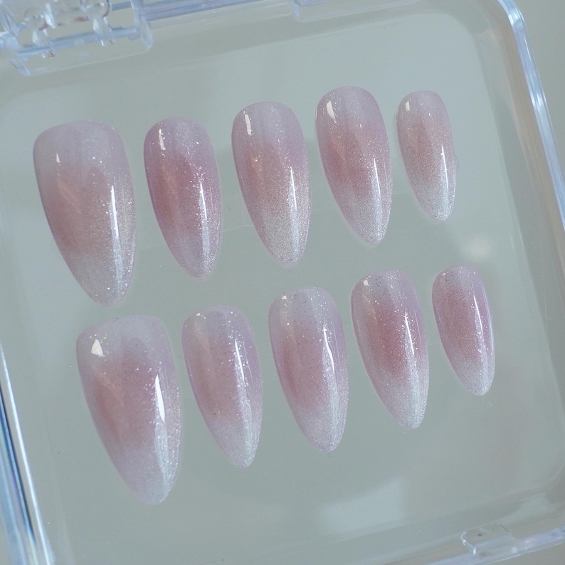 May include: A white ceramic mug with a black handle and the text "But First, Coffee" in a black, handwritten-style font. The mug is on a white surface.