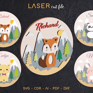 May include: Wooden laser cut file featuring a fox, panda, cat, and bunny in a mountain scene. Each design includes a name, mountains, trees, and a sun. The text "LASER cut file" is at the top, with file type abbreviations at the bottom.