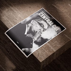 Puede incluir: Póster en blanco y negro con un retrato de Central Cee, con el texto "CENTRAL CEE" y "Can't Rush Greatness". La imagen muestra a una persona exhalando humo. El póster está sobre una superficie de madera.