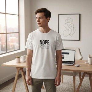 Könnte beinhalten: Weißes T-Shirt mit dem Wort "NOPE" in fetter schwarzer Schrift. Darunter steht der Text "Mood: Offline" und ein Warnsymbol. Das T-Shirt hat kurze Ärmel. Die Person trägt das T-Shirt.