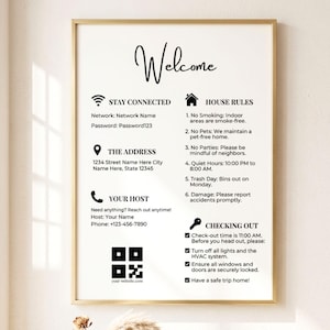 May include: A framed welcome sign with a gold border. The sign includes the word "Welcome" in cursive, along with house rules, Wi-Fi information, address, and contact details. The sign also has a QR code and website address.